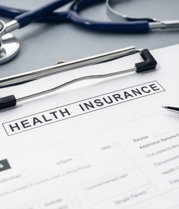 Health Insurance form and stethoscope on desk